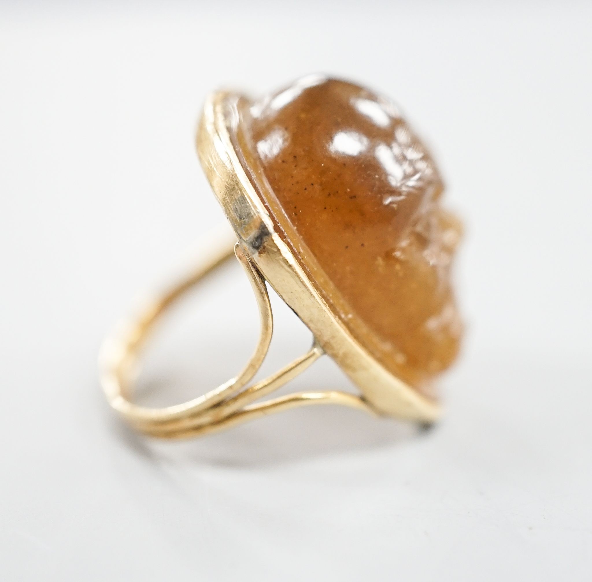 A yellow metal and cabochon brown chalcedony, carved with the face of a gentleman, size K, gross weight 7.3 grams.